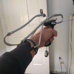 A hand holding a lightweight over-ear headset by its grey headband.