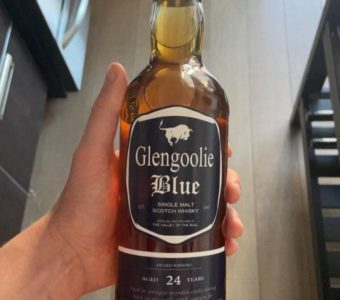 A hand holding a bottle of Glengoolie Blue single malt Scotch whisky.